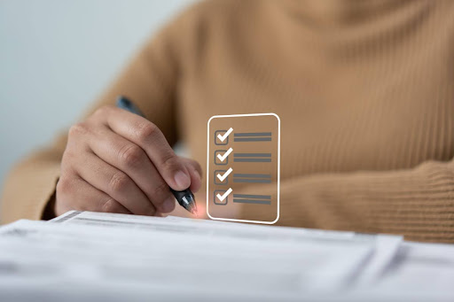 A woman checking off a checklist with a pen.