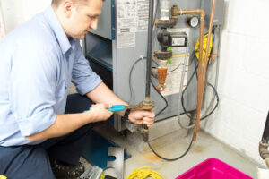An HVAC technician repairing a furnace.